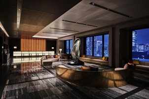 A modern lobby with a curved reception desk, seating areas, and large windows offering city views.