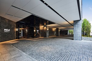 Una entrada moderna de edificio con suelo de baldosas de piedra y puerta de cristal.