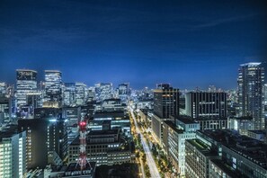 A nighttime cityscape with illuminated skyscrapers and a busy street. - The Royal Park Hotel Iconic Osaka Midosuji (Osaka)