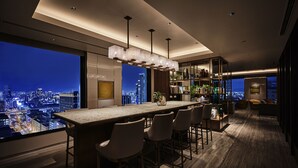 Una cocina moderna con una isla grande, taburetes de bar y vistas a la ciudad.