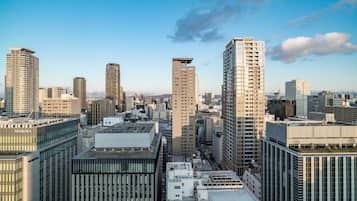 A cityscape with high-rise buildings, including a prominent building with a flat roof and a sign that reads "NOMURA".
