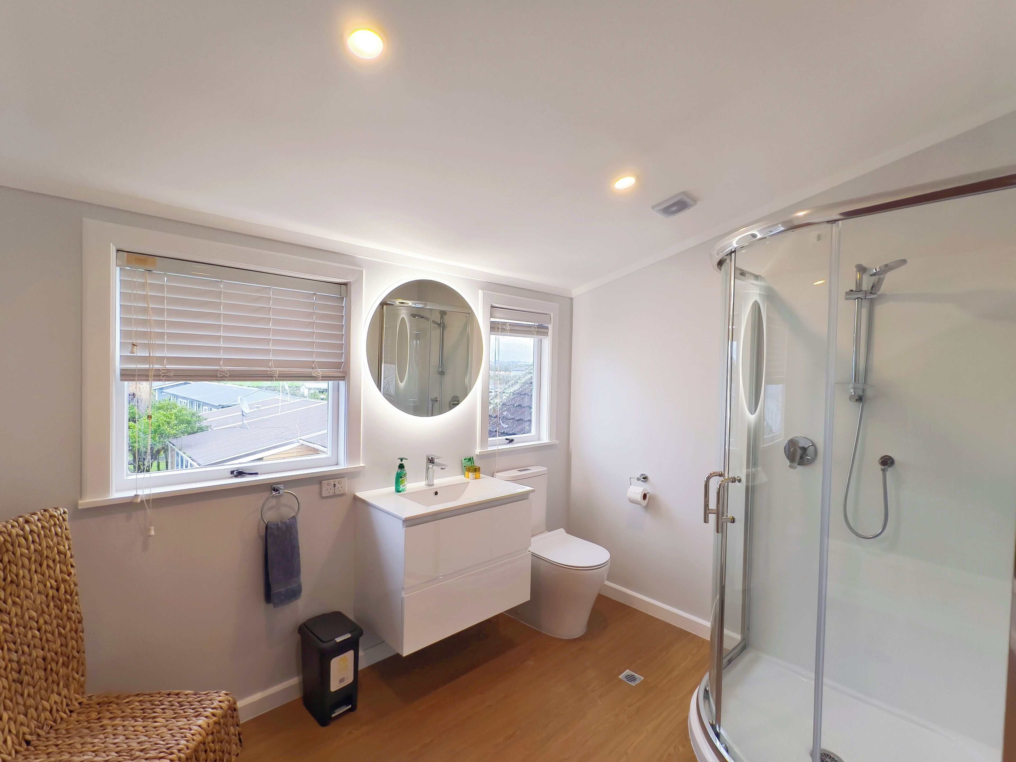Une salle de bain moderne équipée d’une douche, de toilettes, d’un lavabo et d’un grand miroir.