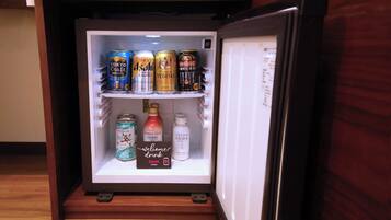 A refrigerator stocked with various beverages including cans of beer and bottles of soda.