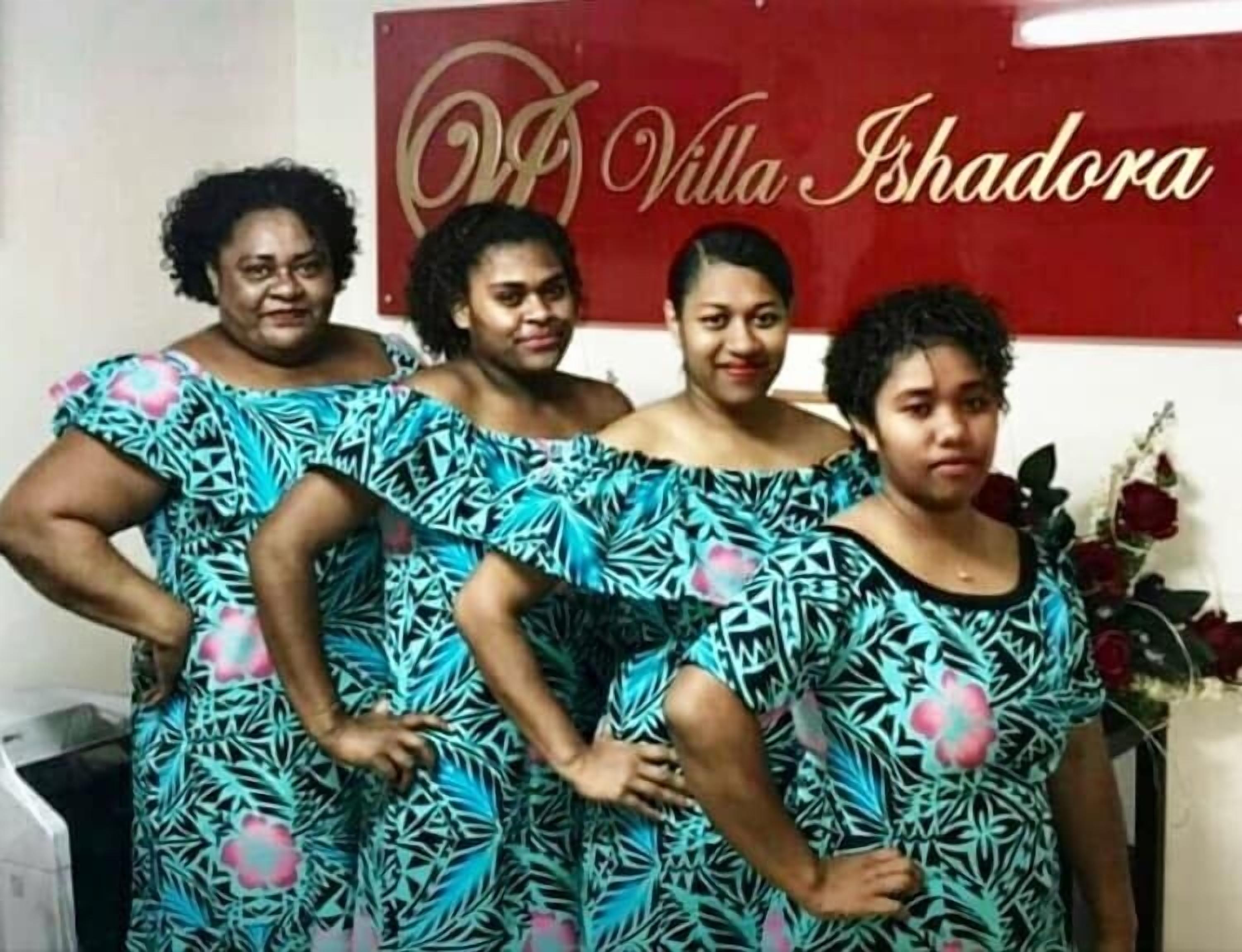 A group of people standing in front of a sign that reads "Villa Ishadora."