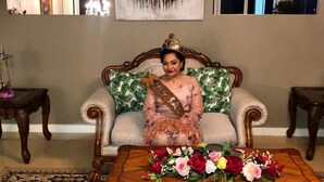 A living room with a sofa, a coffee table with flowers, and a wall-mounted clock. - Villa Ishadora (Nuku'alofa)