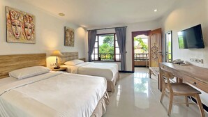 A hotel room with two beds, a desk, a TV, and artwork on the walls. - Sanur Lodge (Denpasar)