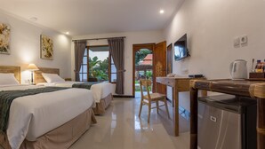 A hotel room with two beds, a desk with a kettle, a television, and a view of the outside. - Sanur Lodge (Denpasar)