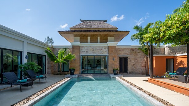A modern pool area with a clear pool, lounge chairs, and potted plants. - Layantara Villas (Thep Krasattri)