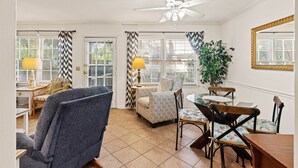 A dining area with a ceiling fan, a dining table, chairs, and a potted plant. - Comfortable 2 bedroom Beach Home located on quiet street (Saint Simons Island)