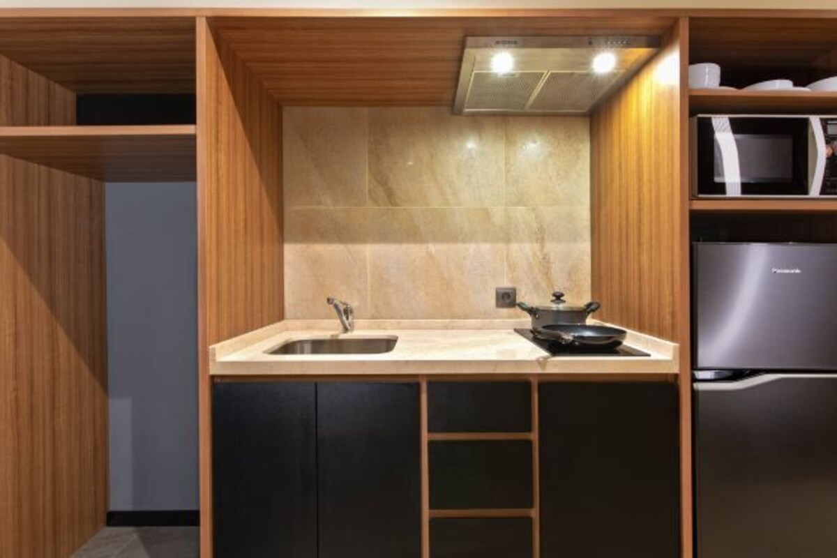 A compact kitchen with a sink, stove, and microwave.