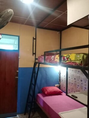 Une chambre avec un lit superposé, une échelle, une petite table et une fenêtre.