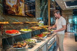 Ein reichhaltiges Buffet mit verschiedenen Speisen, darunter Obst, Salate und Vorspeisen.