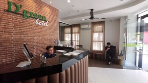 A reception desk with a brick wall and a sign reading "D'green hotel". - D'Green Hotel Kuching (Kuching)