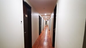 A long, narrow hallway with wooden flooring and white walls. - D'Green Hotel Kuching (Kuching)