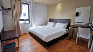 A hotel room with a bed, desk, chair, and a window with curtains. - D'Green Hotel Kuching (Kuching)