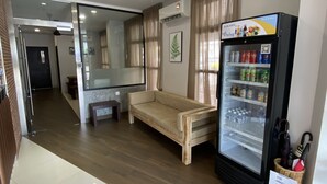 A hotel room with a wooden bench, a minibar, a ceiling fan, and a large mirror. - D'Green Hotel Kuching (Kuching)