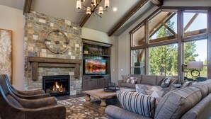 Una sala de estar acogedora con chimenea de piedra, asientos cómodos y ventanas amplias.
