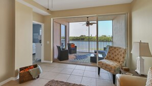 A spacious balcony with a ceiling fan, a wicker basket, and a patterned armchair.