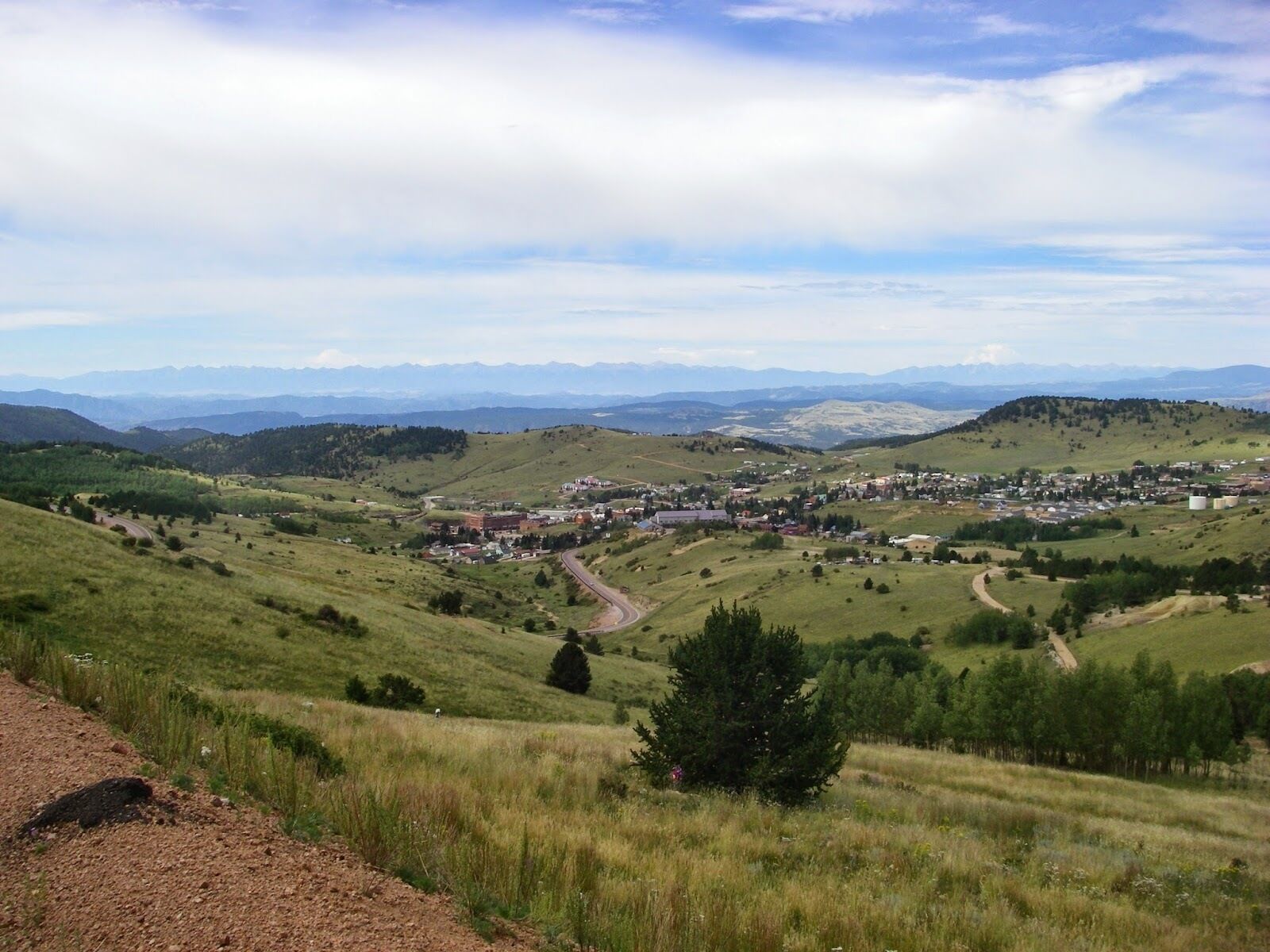 A rural landscape with a small town nestled among rolling hills.