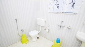 Une salle de bain équipée de toilettes, d’un bidet et d’un lavabo.