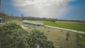 Un grand bâtiment doté d’un toit végétalisé et, en arrière-plan, d’un champ d’herbe.