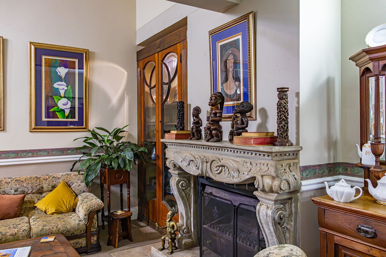 Una sala de estar con chimenea, un sofá, una mesa de centro y una estantería.