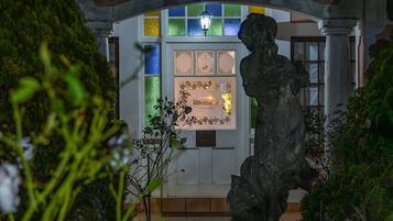 Una estatua en un jardín con un edificio al fondo, que presenta vidrieras y un letrero que dice 'Westminster'.