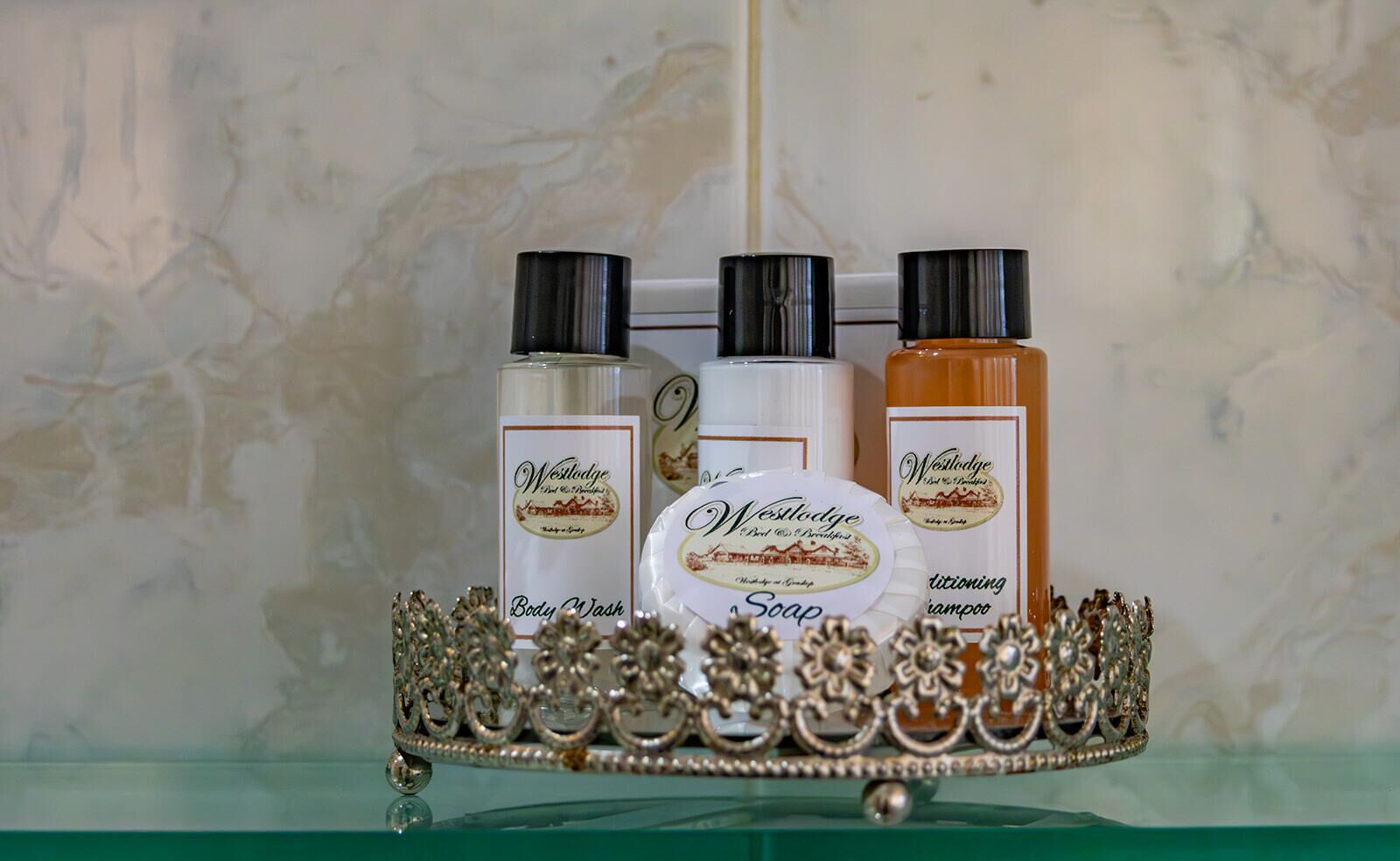 A tray with West Lodge body wash, soap, and shampoo bottles.