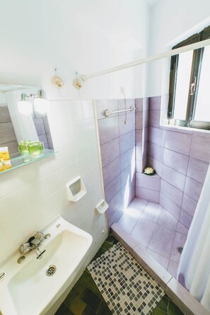 Departamento estándar, varias camas, balcón | Baño | Regadera, amenidades de baño gratuitas, secadora de cabello, toallas 