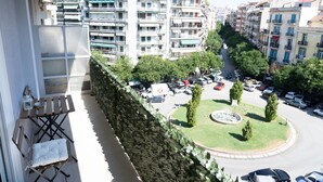 A balcony with a view of a city street, a roundabout, and parked cars. - Zennova 5 Antigonidon Sq (Thessaloniki)