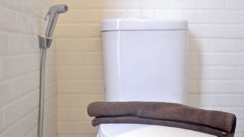 Standaard kamer | Badkamer | Een douche, pantoffels, handdoeken, zeep