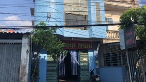 A building with a blue facade, a sign reading "NHÃ NGHI," and a motorcycle parked in front. - Van Anh Motel (Hai Phong)
