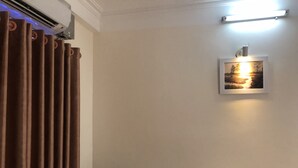 A hotel room with a bed, a wall-mounted picture, and a ceiling light. - Van Anh Motel (Hai Phong)
