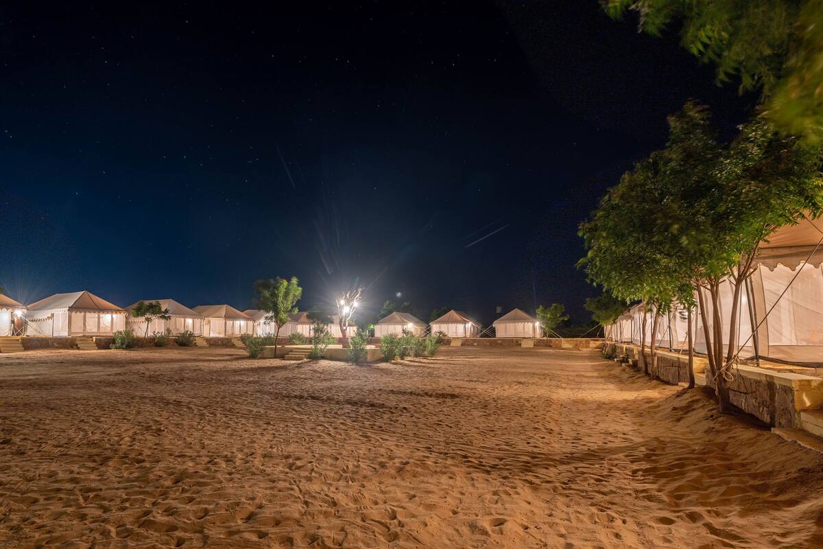 Ein Wüstencamp mit Zelten und sternenklarer Nacht.