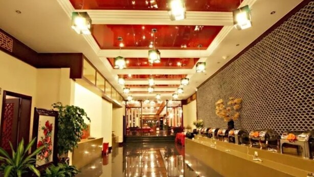 A hotel lobby with a polished floor, a reception desk, and a decorative wall with a geometric pattern. - Floral Hotel Dali Zhonghefang (Dali)