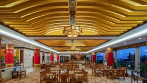 A spacious hotel lobby with a high ceiling, patterned carpet, and wooden furniture. - Floral Hotel Dali Zhonghefang (Dali)