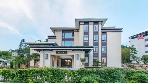A modern hotel with a symmetrical facade, multiple floors, and a central entrance. - Floral Hotel Enshi Xiaoxihu Yihao (Enshi)