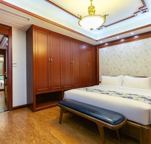 A bedroom with a large bed, wooden wardrobe, bench, and a chandelier. - Floral Hotel Enshi Xiaoxihu Yihao (Enshi)