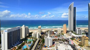 Eine Küstenstadt mit Hochhäusern, einem Strand und einem Schwimmbadkomplex.