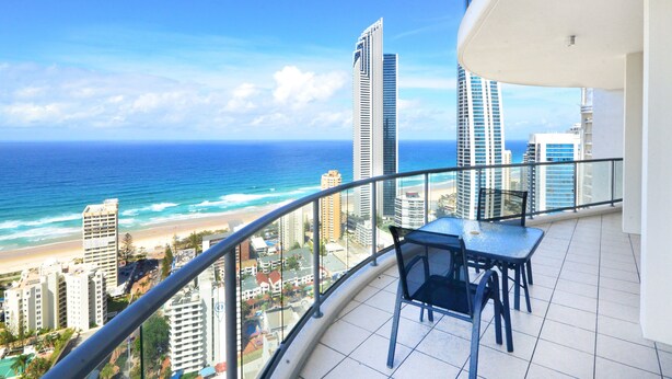 Ein Balkon mit Blick auf das Meer und hohe Gebäude.