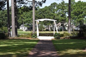 Stroll through lush gardens beneath a charming arbor, perfect for intimate gatherings.