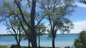 Une terrasse avec vue sur un lac, entourée d’arbres.