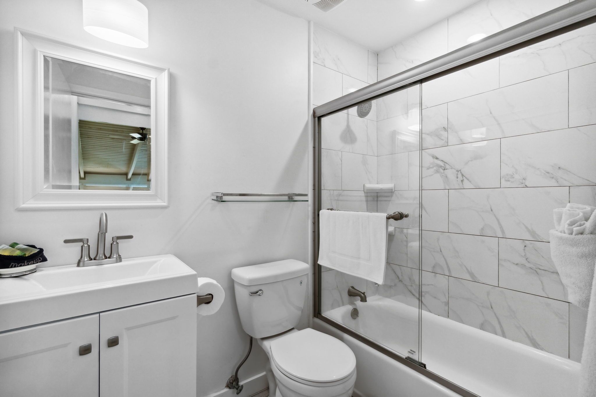 A modern bathroom with a toilet, sink, and shower area.