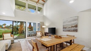 Ein geräumiger Essbereich mit Holztisch, Bänken und Fernseher.