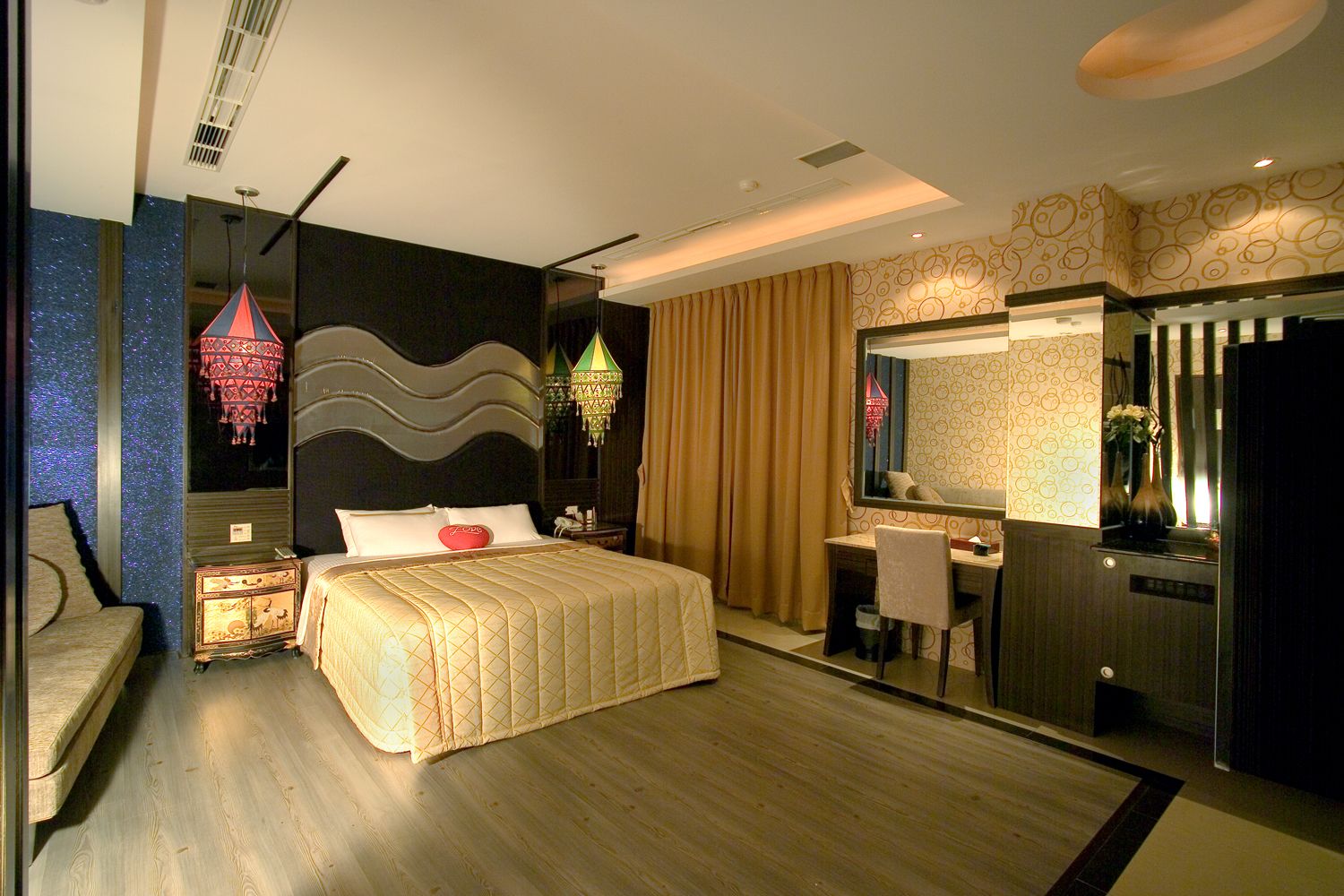 A modern hotel room with a large bed, a desk, a vanity, and a mirror.