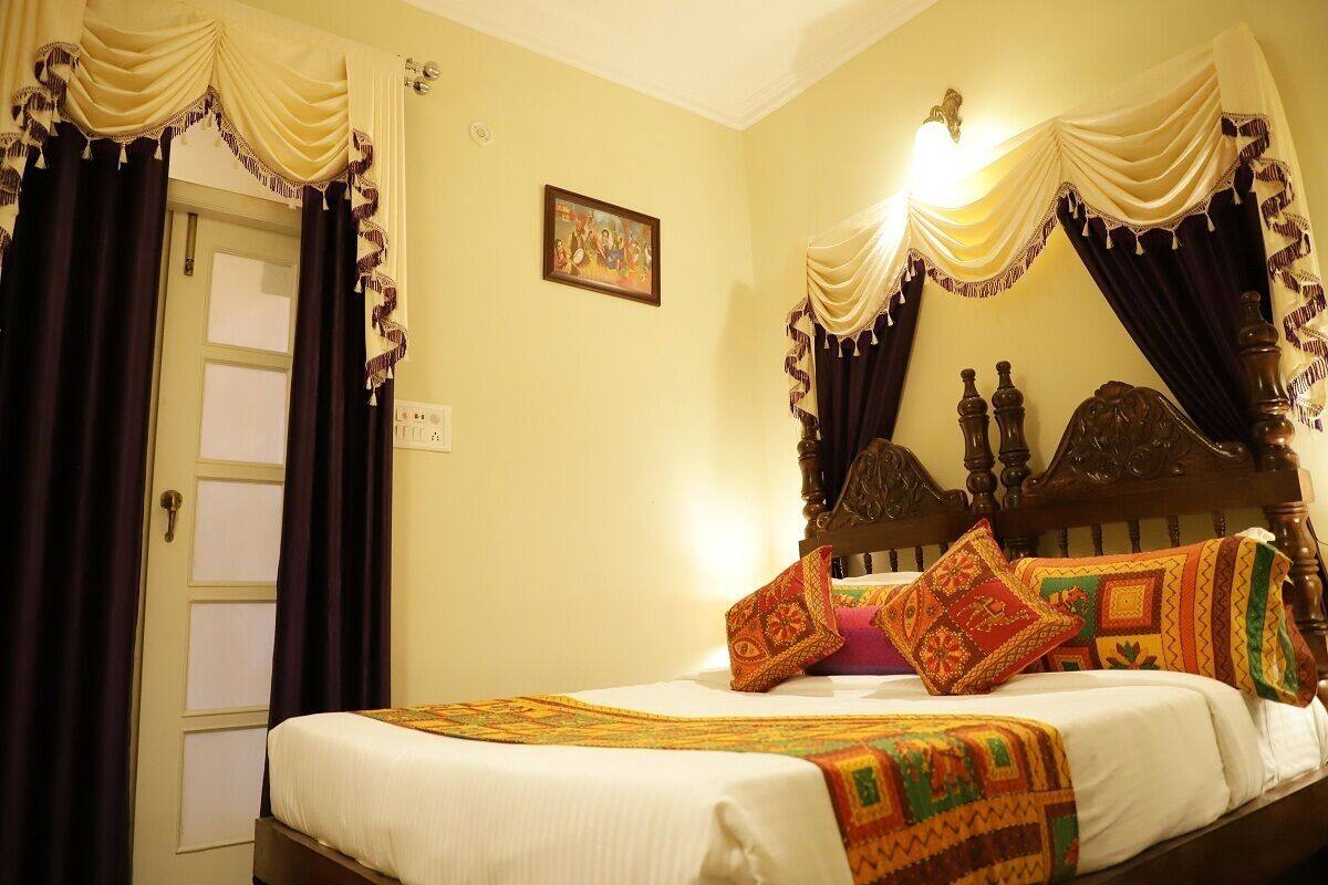 A bedroom with a wooden bed, patterned pillows, and draped curtains.