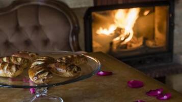 A table with pastries, a cup of coffee, and rose petals.