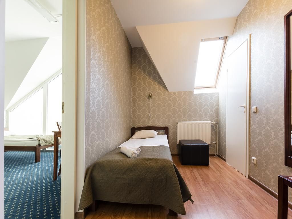 Une chambre à coucher avec un lit, un radiateur, une fenêtre et une porte.