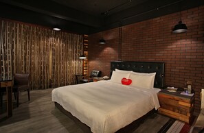 Une chambre d’hôtel moderne, dotée d’un grand lit, d’un bureau et d’une chaise.