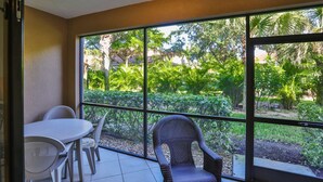 A room with a large window, a table, and two chairs.
